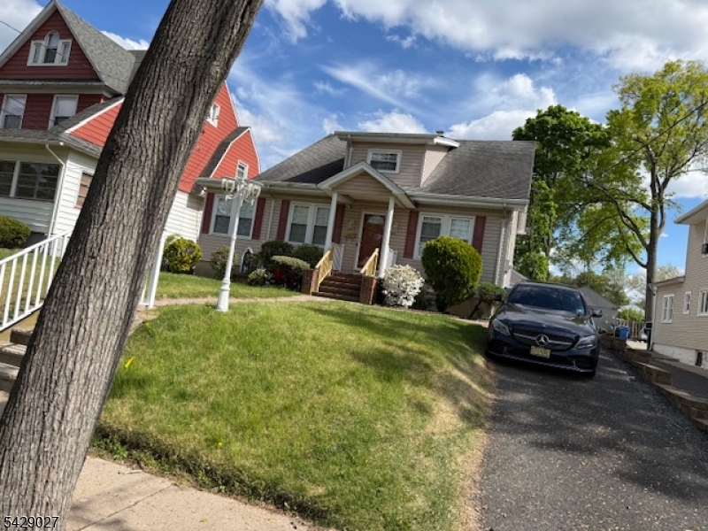 305 Penfield Place Dunellen, NJ 08812 - Photo 1 of 11 a car parked in front of a brick house with a yard