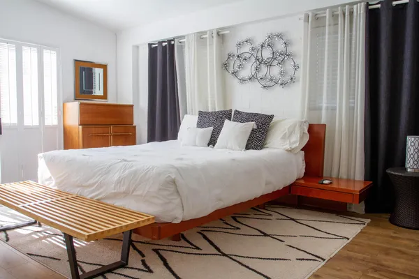 a bedroom with a bed and a painting on the wall