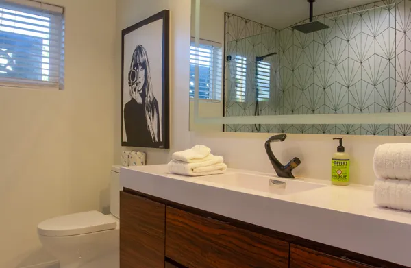 a bathroom with a sink a toilet and mirror