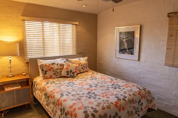 a large bed sitting in a bedroom next to a window