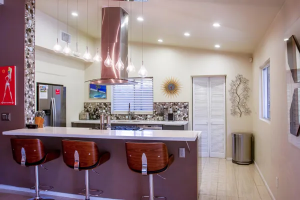 a kitchen with stainless steel appliances granite countertop a sink and a refrigerator