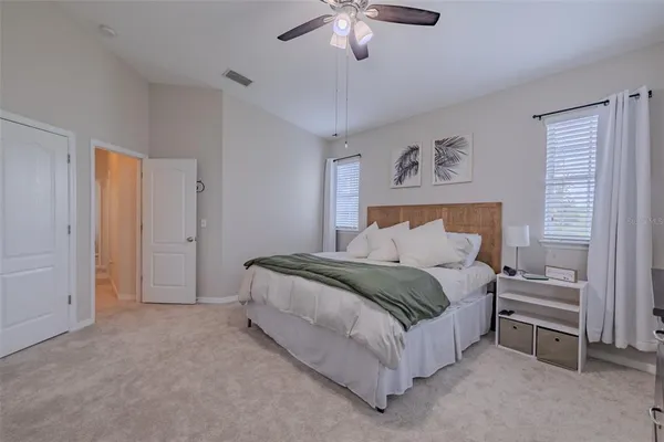 a spacious bedroom with a bed and a chandelier