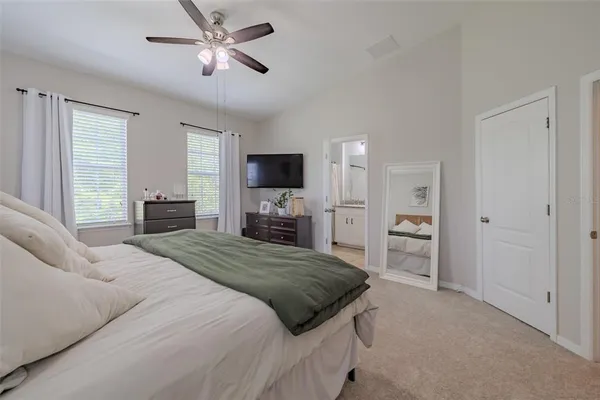a spacious bedroom with a bed and a flat screen television