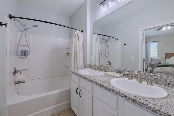 a bathroom with a granite countertop sink mirror and a bath tub