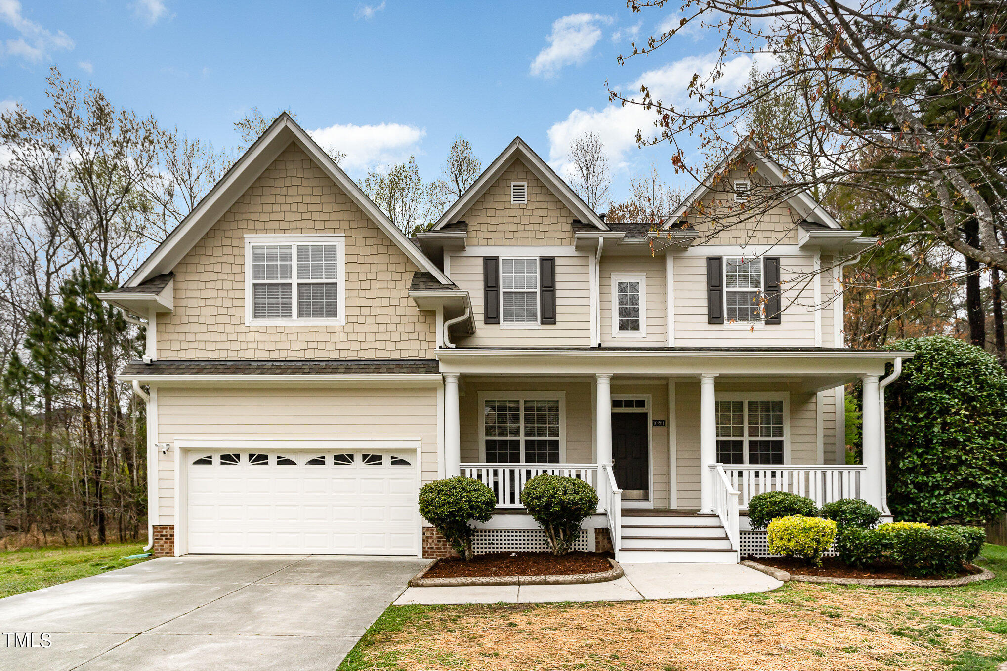 a front view of a house with a yard and potted plants