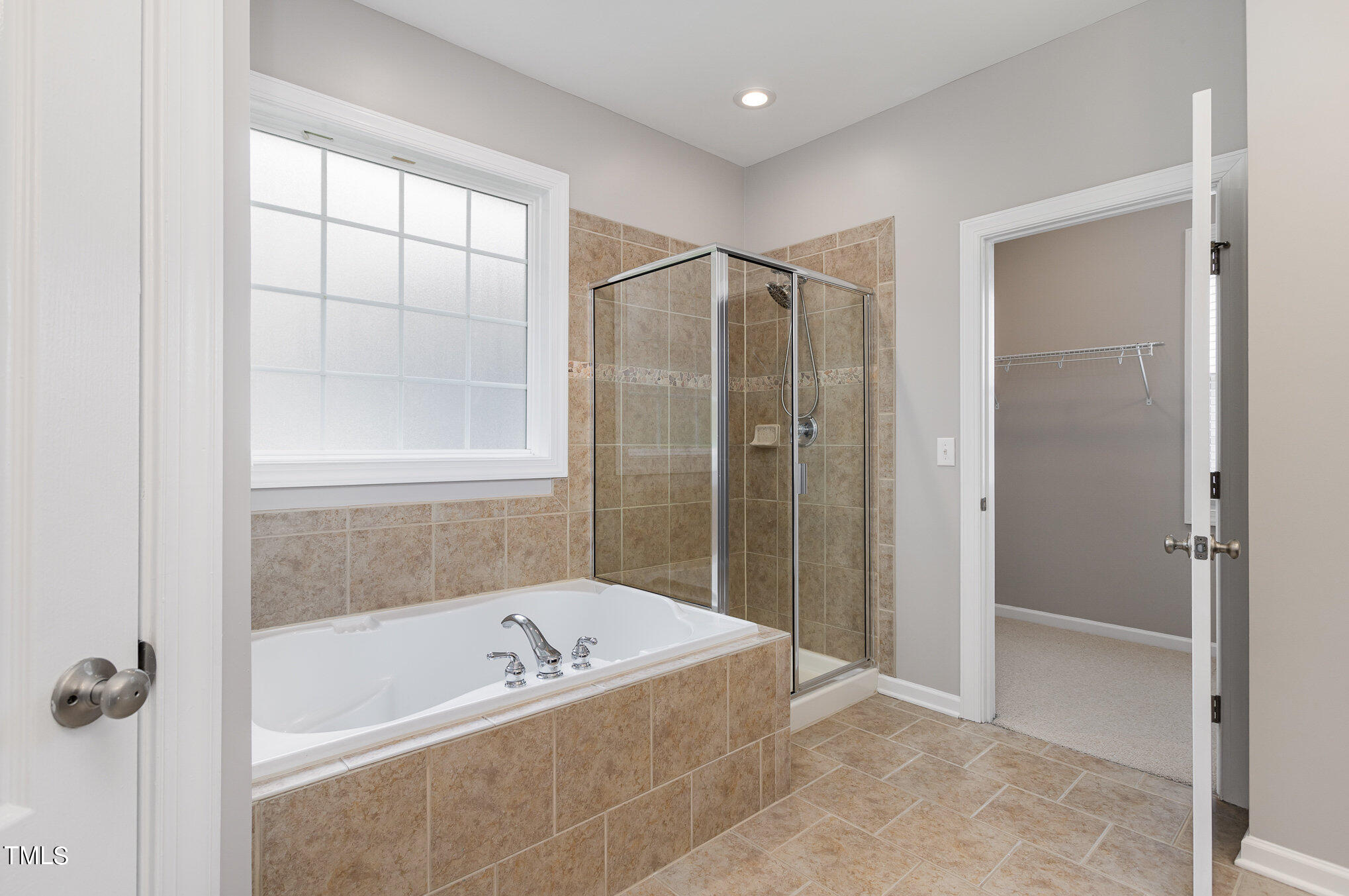 10201 Darling Street Raleigh, NC 27613 - Photo 16 of 23 a bathroom with a bathtub and a shower