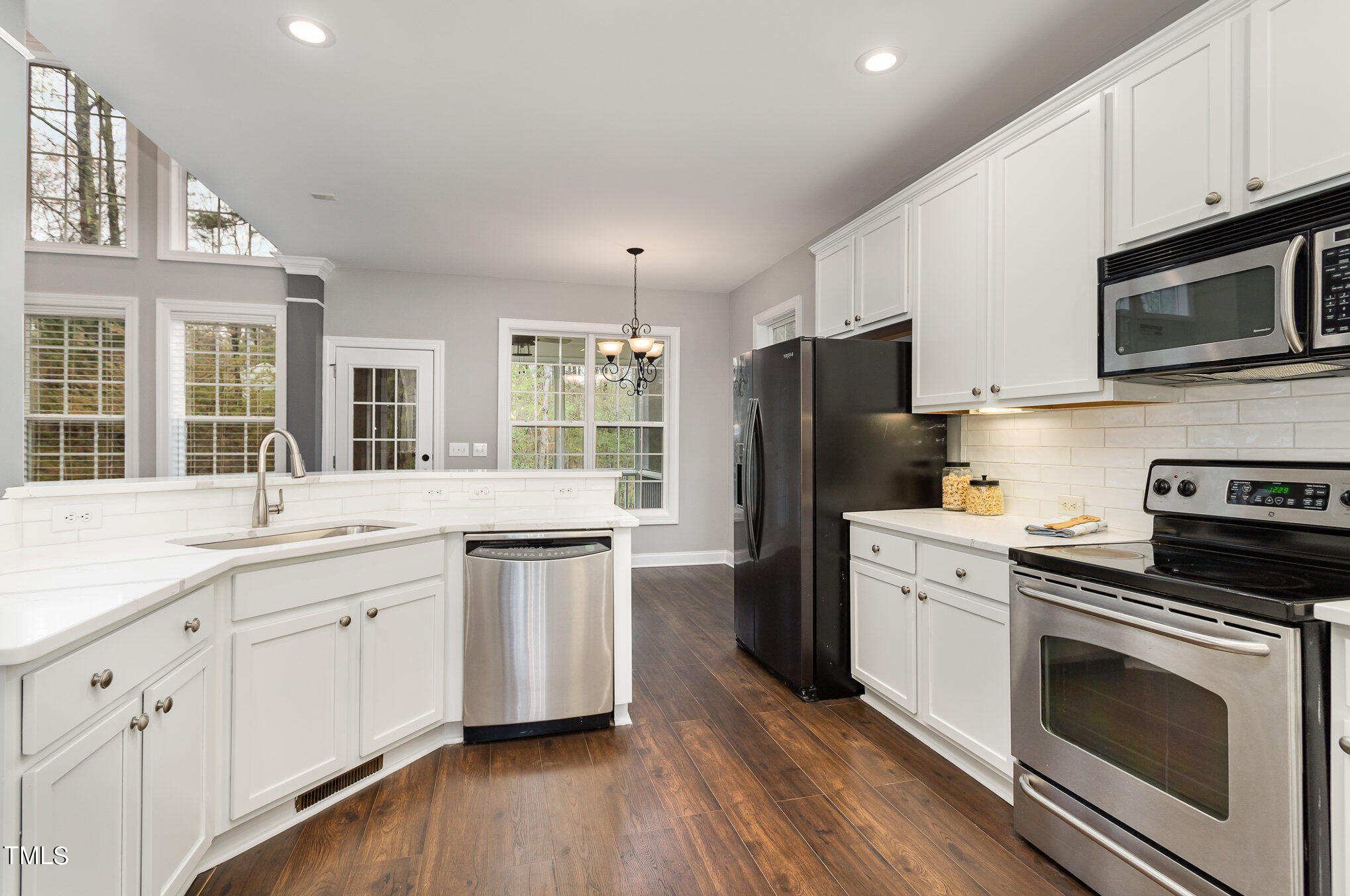 10201 Darling Street Raleigh, NC 27613 - Photo 6 of 23 a kitchen with granite countertop appliances cabinets and a wooden floor