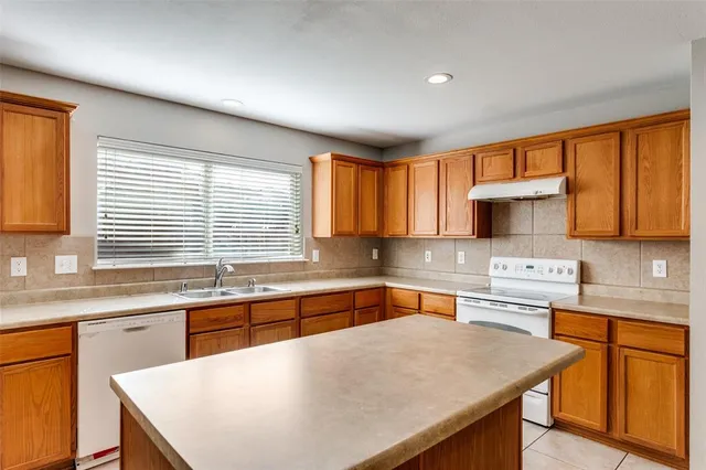 a kitchen with stainless steel appliances granite countertop a sink a stove and cabinets