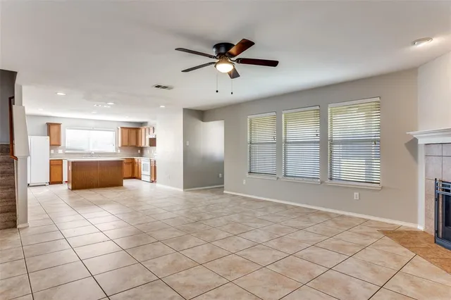 a view of an empty room with a window and kitchen