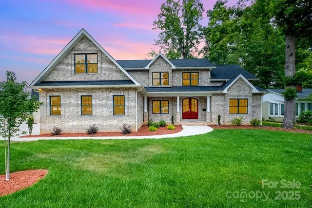 a front view of a house with a yard and trees