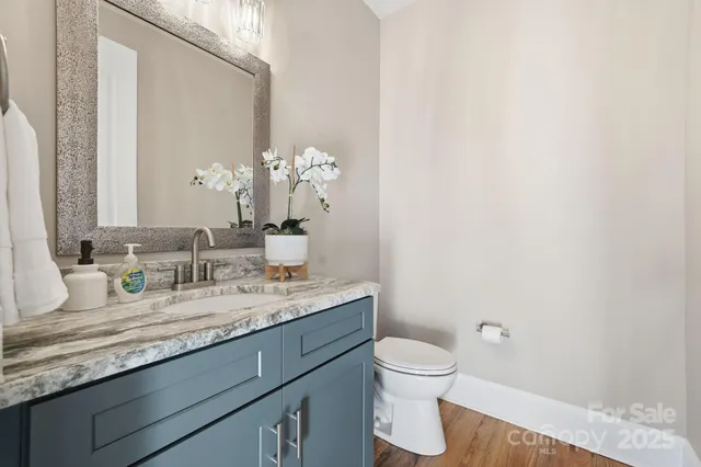 a bathroom with a granite countertop sink mirror and toilet