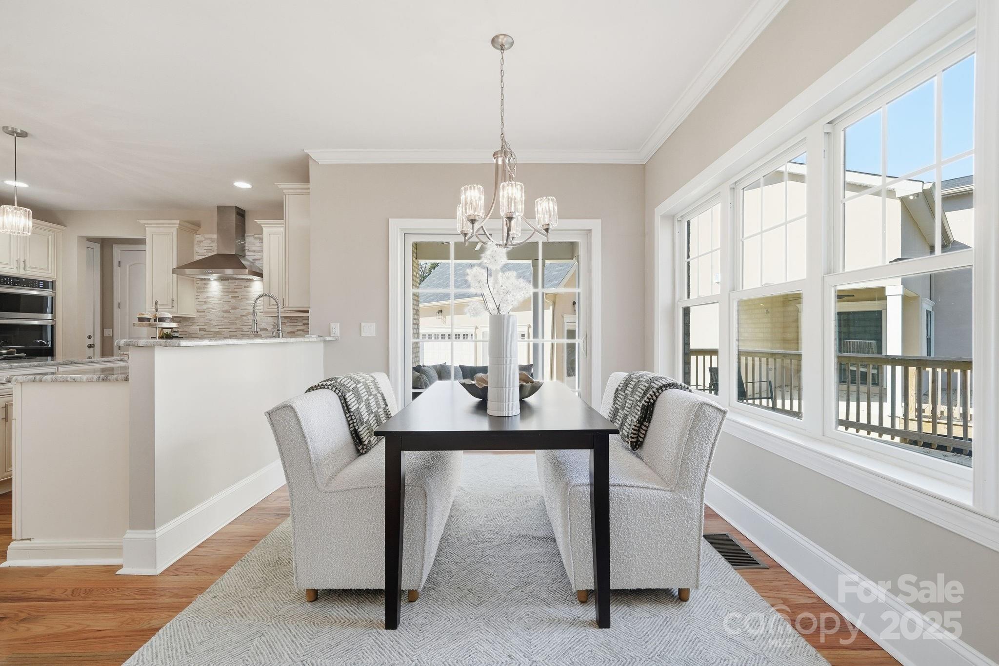 101 McAlway Road Charlotte, NC 28211 - Photo 22 of 40 a dining room with furniture a chandelier and wooden floor