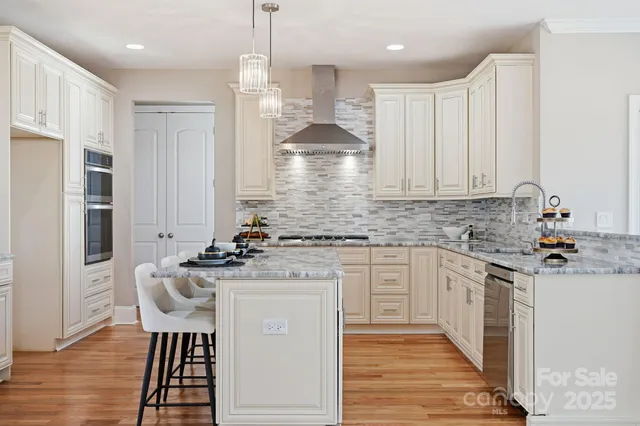 a kitchen with stainless steel appliances kitchen island granite countertop a stove a sink and a refrigerator