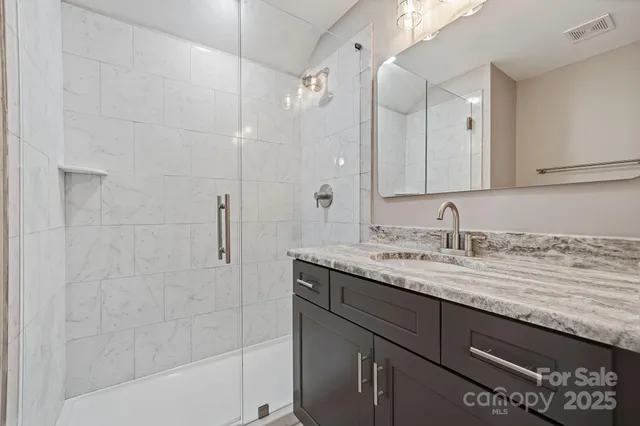 a bathroom with a granite countertop sink mirror and a bath tub
