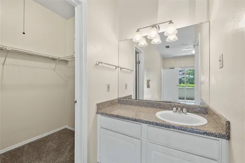 a bathroom with a granite countertop sink a mirror and a shower