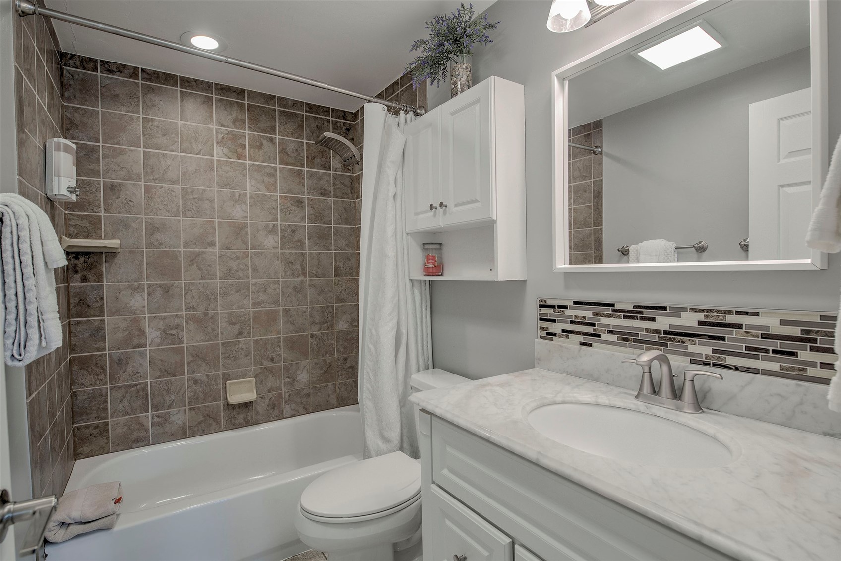 472 Ryan Gulch Road Silverthorne, CO 80498 - Photo 15 of 36 a bathroom with a granite countertop sink a toilet a mirror a bathtub and shower