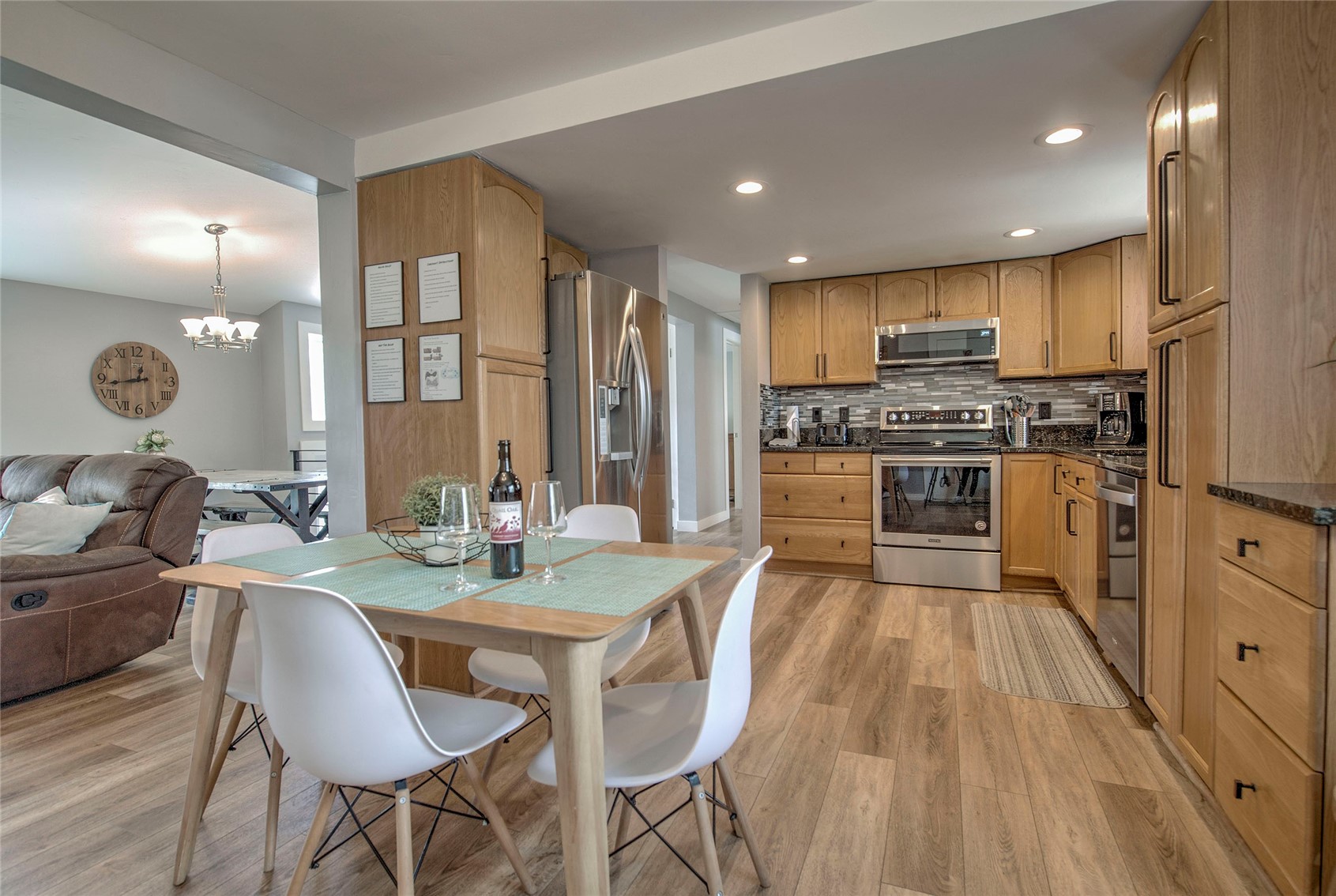 472 Ryan Gulch Road Silverthorne, CO 80498 - Photo 5 of 36 a kitchen with stainless steel appliances granite countertop a stove top oven a sink dishwasher and a dining table with wooden floor