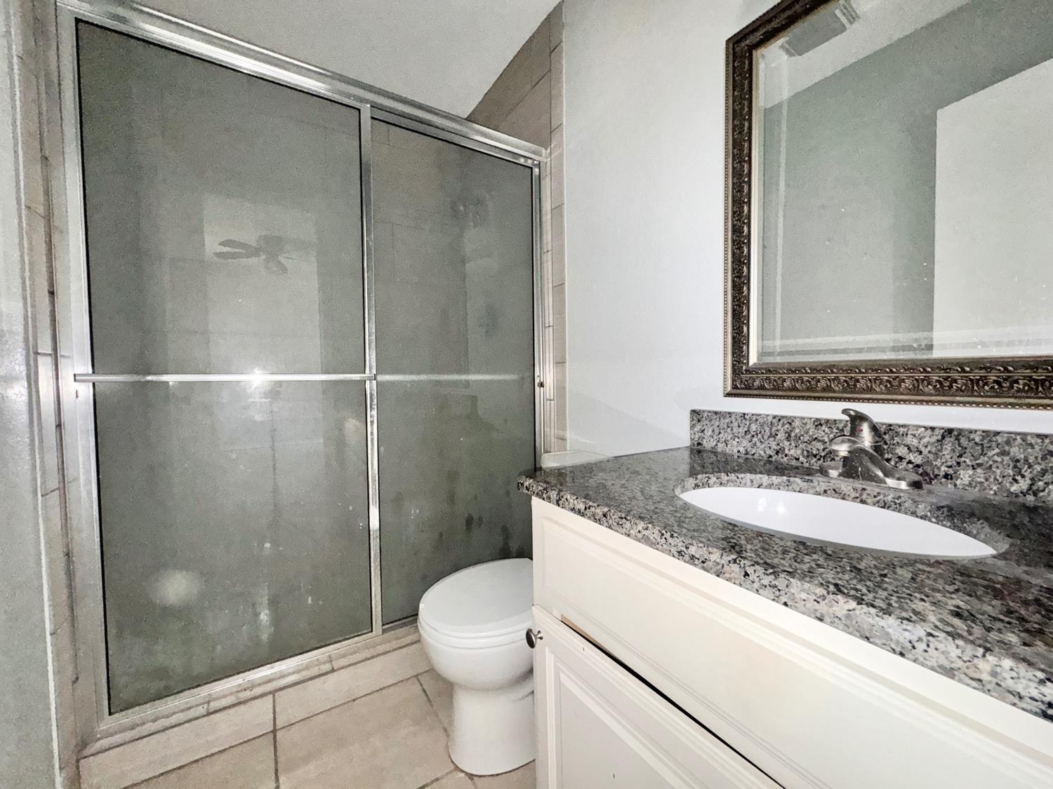 4707 48th Street Lubbock, TX 79414 - Photo 12 of 18 a bathroom with a granite countertop sink toilet and shower