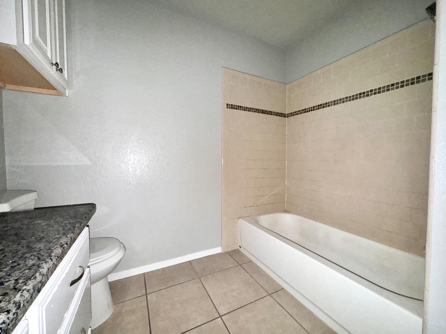 4707 48th Street Lubbock, TX 79414 - Photo 15 of 18 a bathroom with a granite countertop bathtub shower and sink