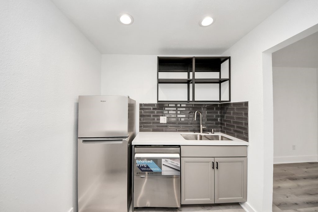 1014 Graham Drive Tomball, TX 77375 - Photo 12 of 37 a kitchen with a sink and a refrigerator
