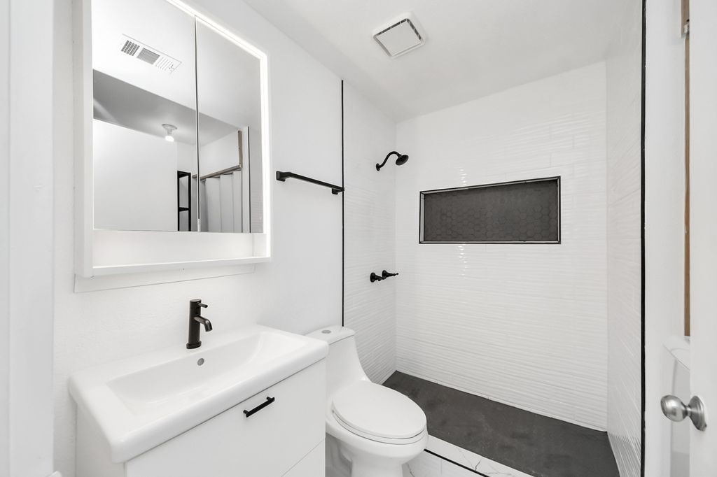 1014 Graham Drive Tomball, TX 77375 - Photo 18 of 37 a bathroom with a toilet a sink and mirror