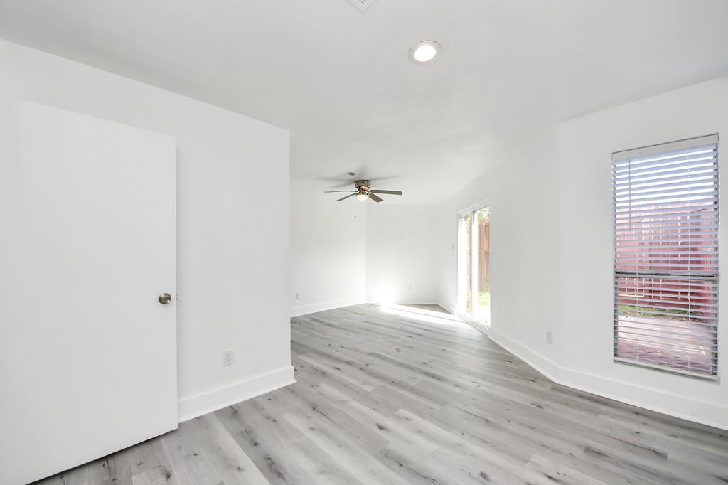1014 Graham Drive Tomball, TX 77375 - Photo 25 of 37 an empty room with wooden floor ceiling fan and windows