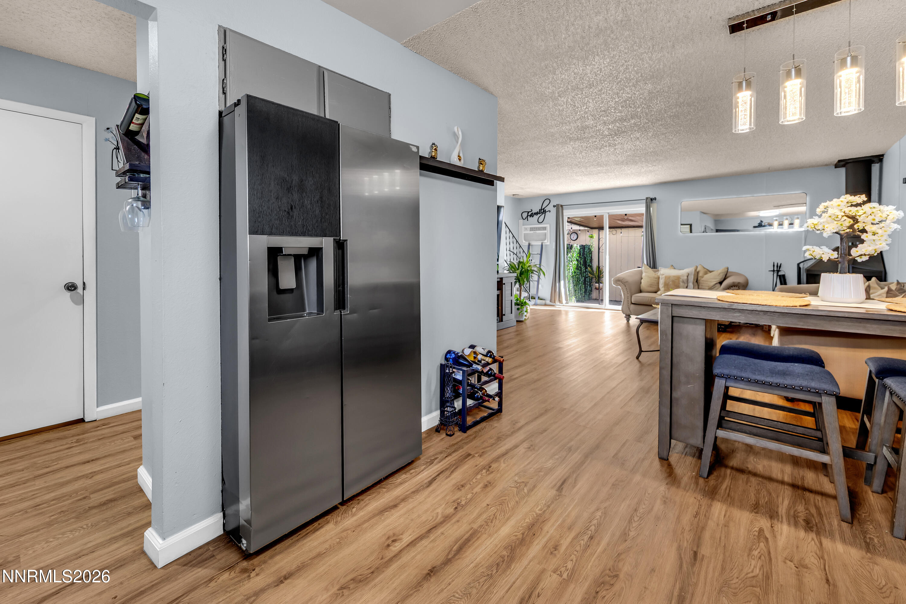 562 Smithridge Park Reno, NV 89502 - Photo 7 of 43 a kitchen with stainless steel appliances refrigerator wooden floor dining table and chairs