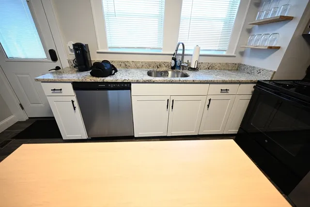 a kitchen with a sink a stove and cabinets