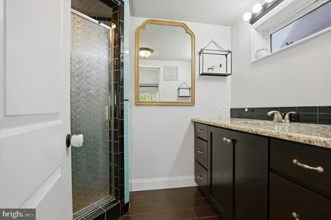a bathroom with a granite countertop sink and mirror