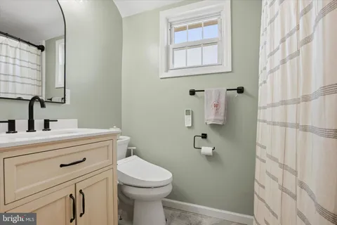 a bathroom with a toilet a sink a vanity and mirror