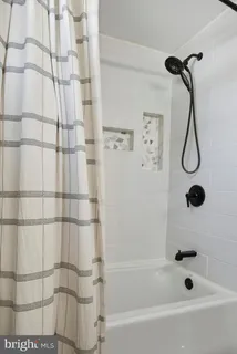 a bathroom with a bath tub with a shower