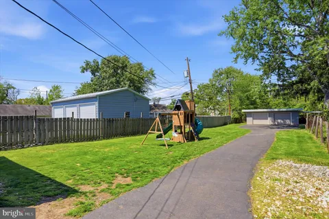 a view of a house with a yard and large tree