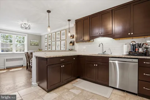 a kitchen with stainless steel appliances granite countertop wooden cabinets a sink and dishwasher
