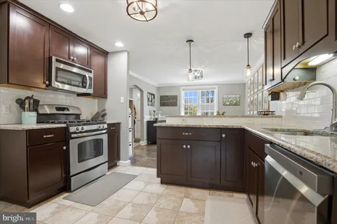 a kitchen with stainless steel appliances granite countertop a stove sink and cabinets
