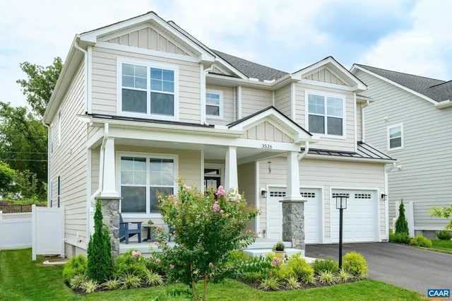 a front view of a house with a yard and plants