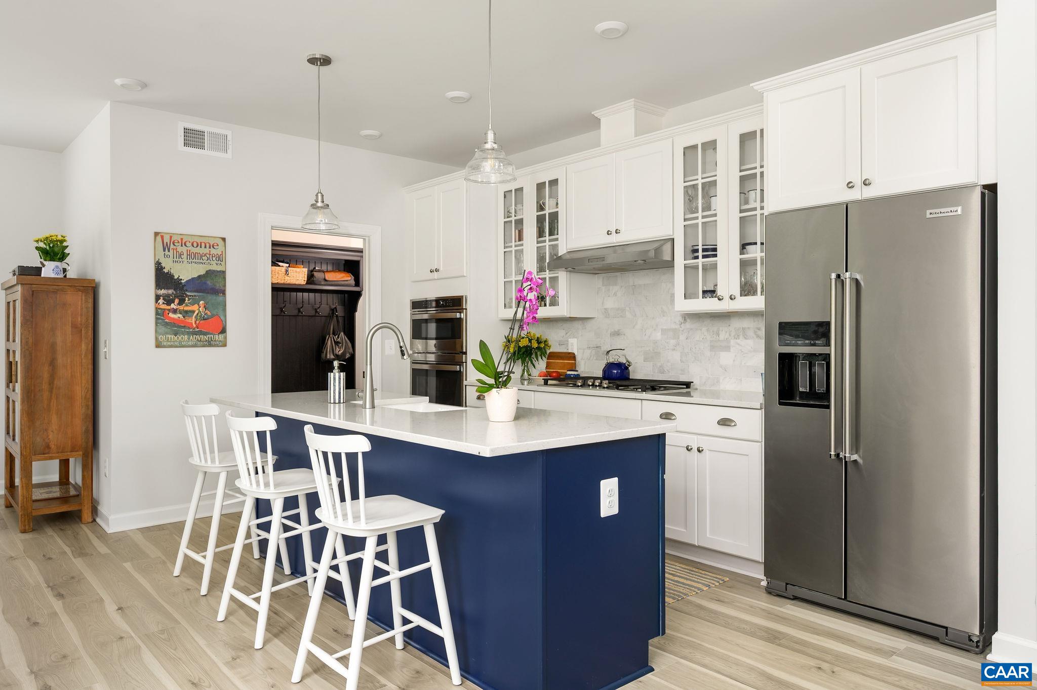 3526 Thicket Run Place Charlottesville, VA 22911 - Photo 11 of 36 a kitchen with stainless steel appliances a refrigerator a stove a sink and chairs