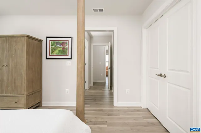 a view of a hallway with wooden floor and closet