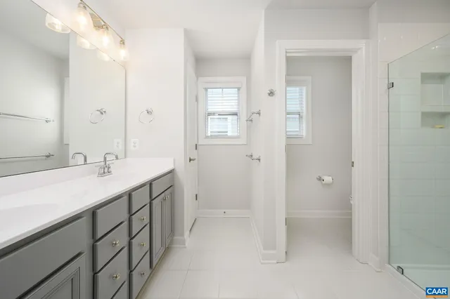 a spacious bathroom with a shower sink and mirror