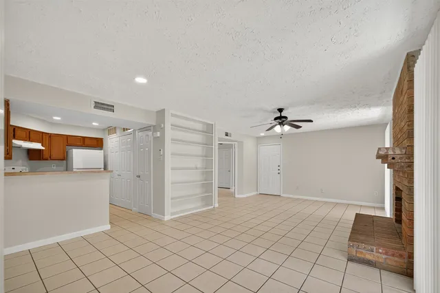 an empty room with windows and fireplace