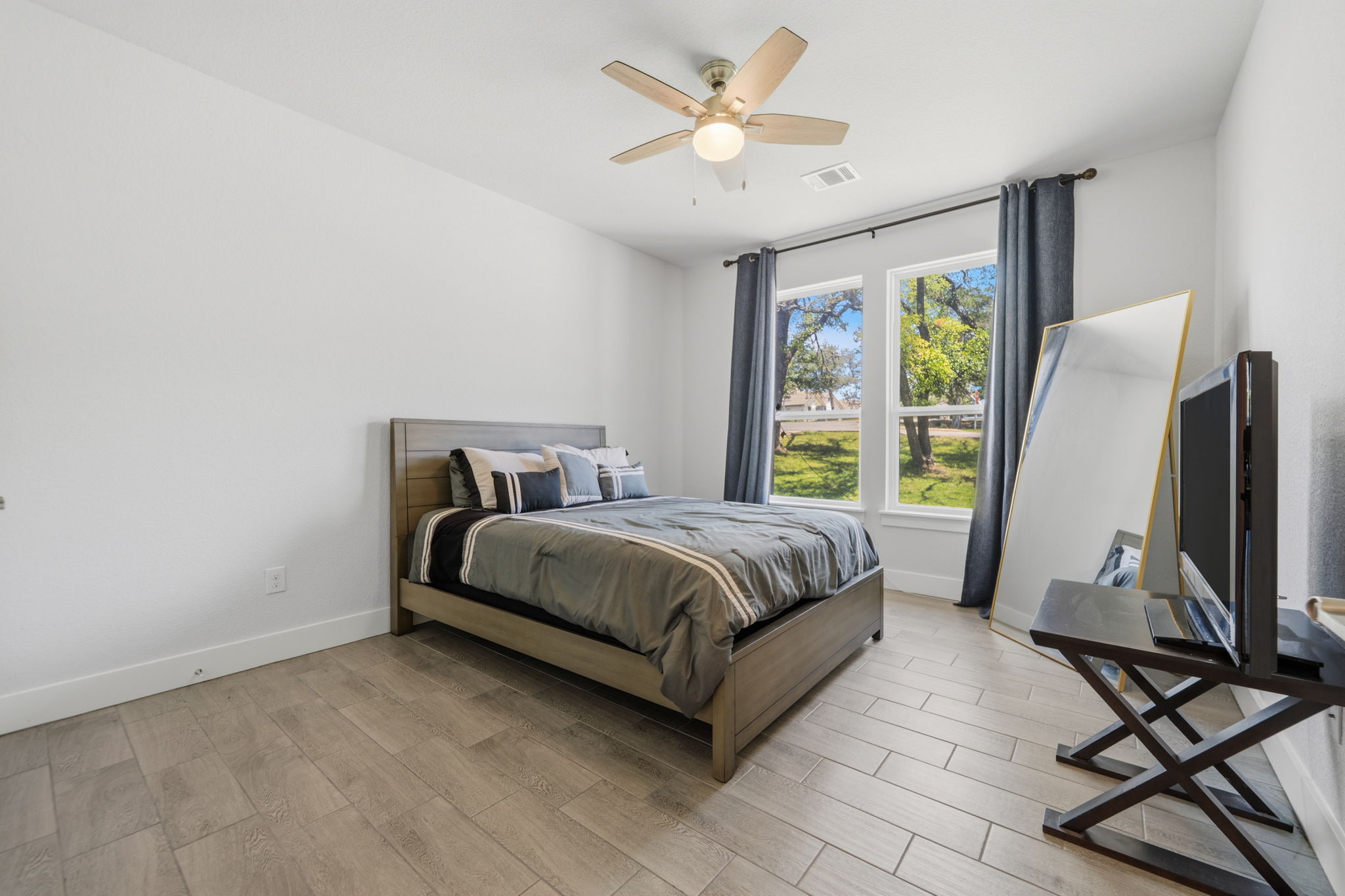 18605 Masters Cove Point Venture, TX 78645 - Photo 21 of 40 Wood-finish flooring anchors this bright room featuring multiple windows, a ceiling fan with integrated lighting, and crisp white walls