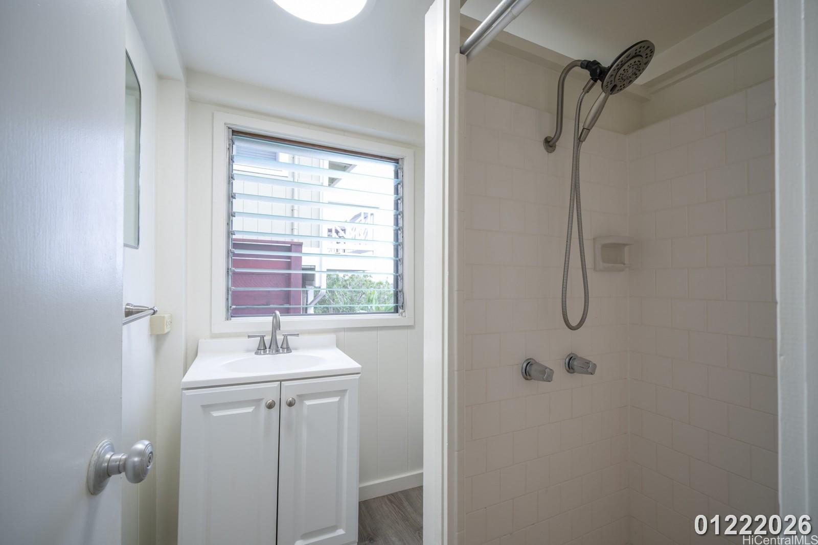 3033 Woolsey Place, Unit DOWNSTAIRS) Honolulu, HI 96822 - Photo 11 of 20 a bathroom with a sink a mirror and shower