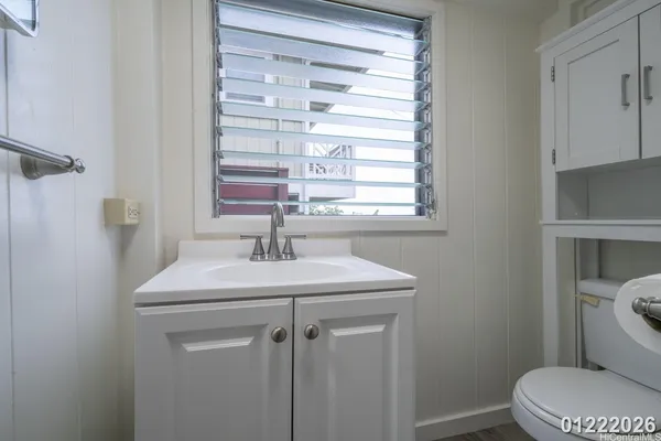 a bathroom with a sink a toilet and a window