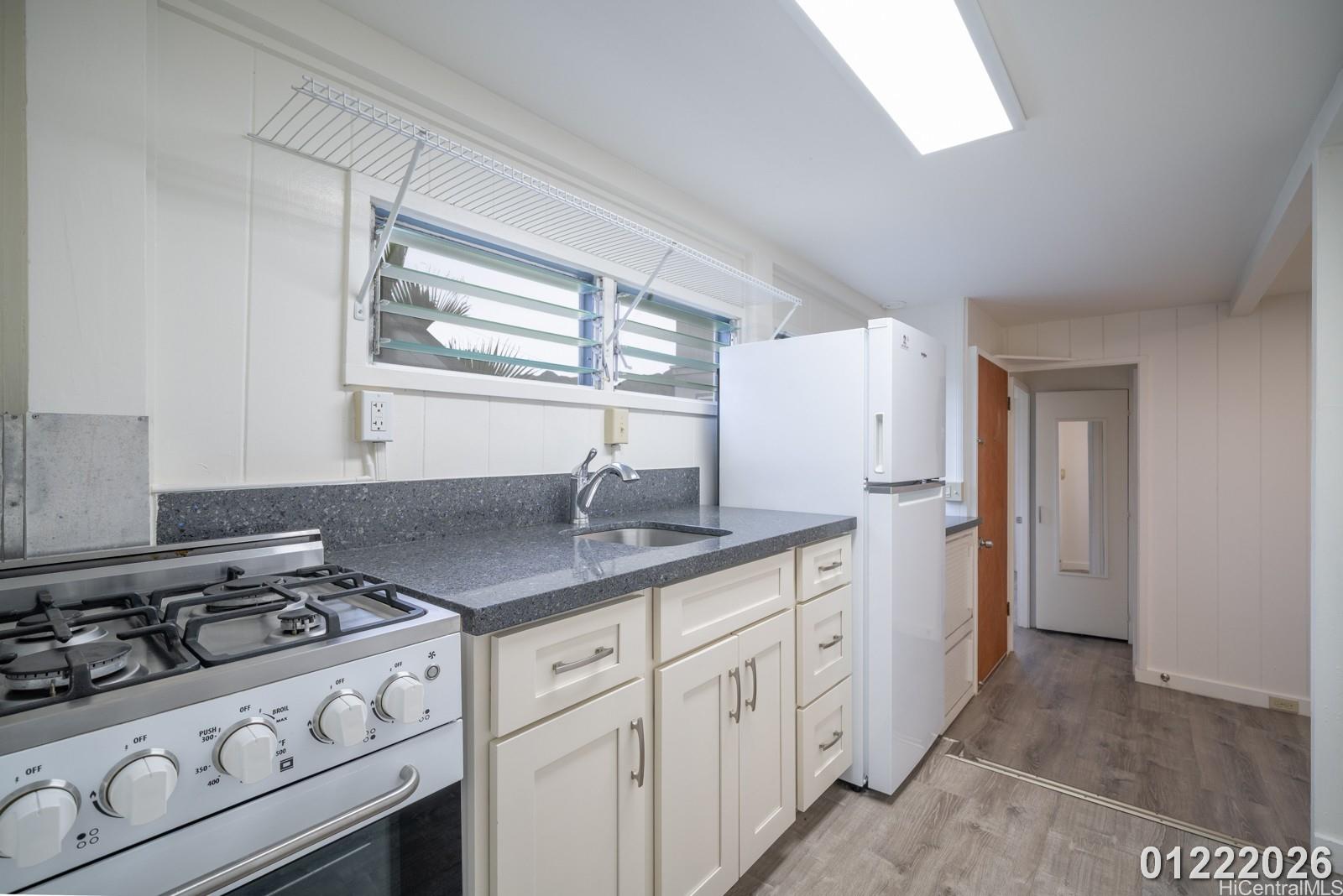 3033 Woolsey Place, Unit DOWNSTAIRS) Honolulu, HI 96822 - Photo 15 of 20 a kitchen with cabinets appliances and a window