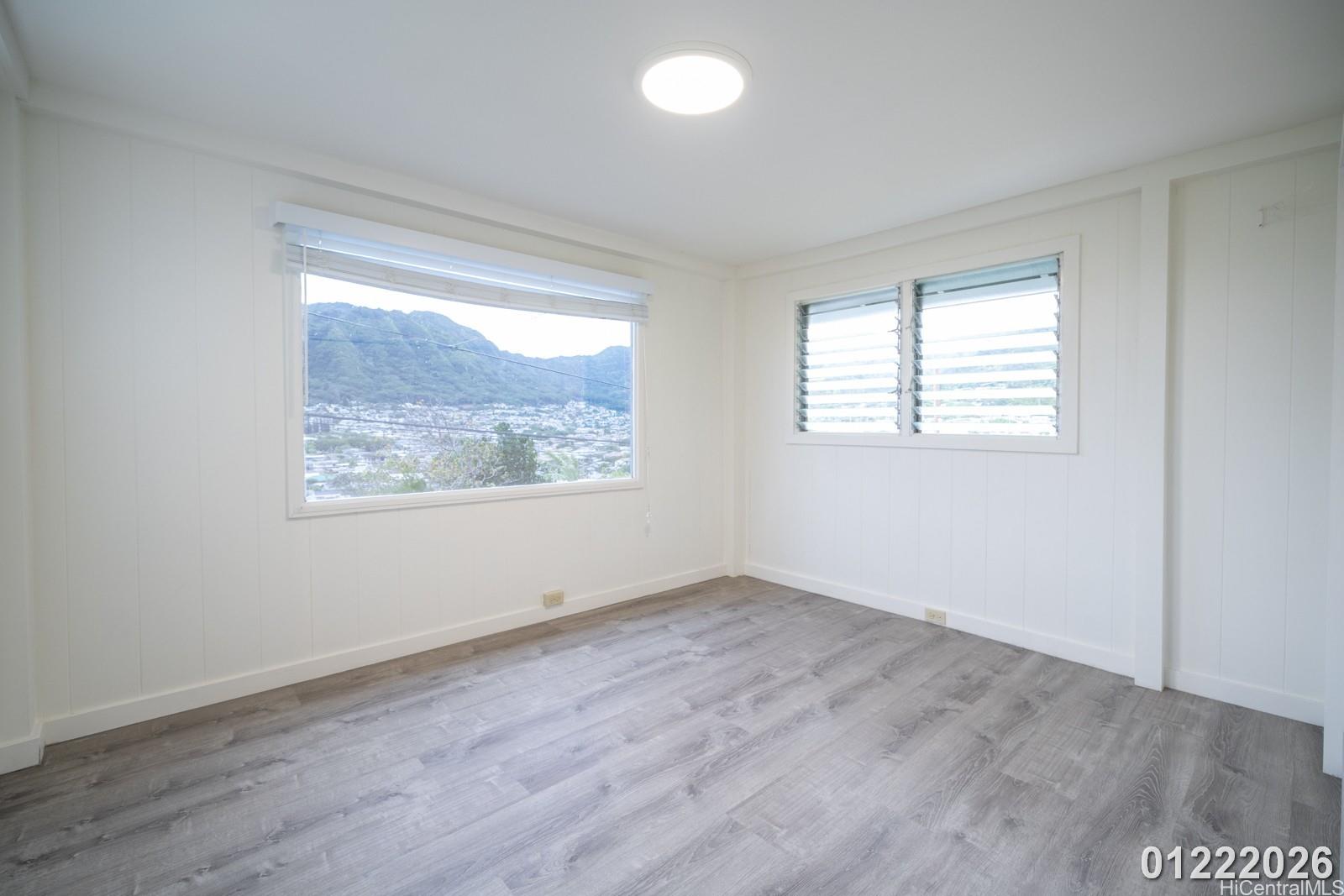 3033 Woolsey Place, Unit DOWNSTAIRS) Honolulu, HI 96822 - Photo 18 of 20 an empty room with wooden floor and windows