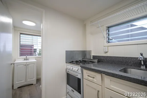 a kitchen with stainless steel appliances a sink stove and cabinets