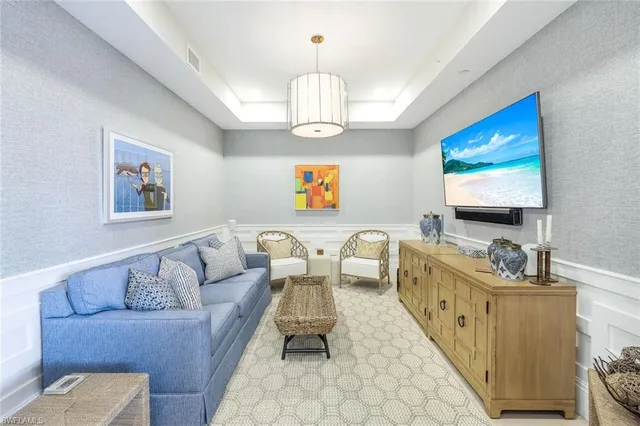a living room with furniture a chandelier and a flat screen tv