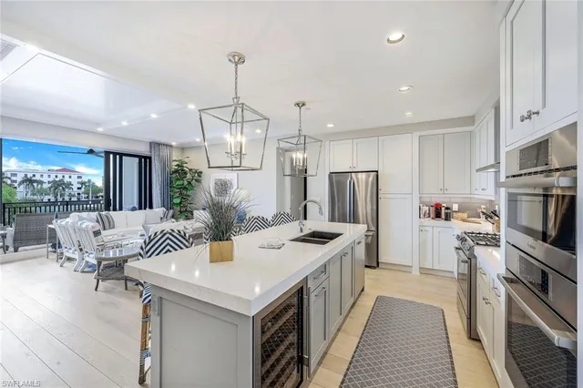 a kitchen with stainless steel appliances granite countertop a sink a stove and a refrigerator