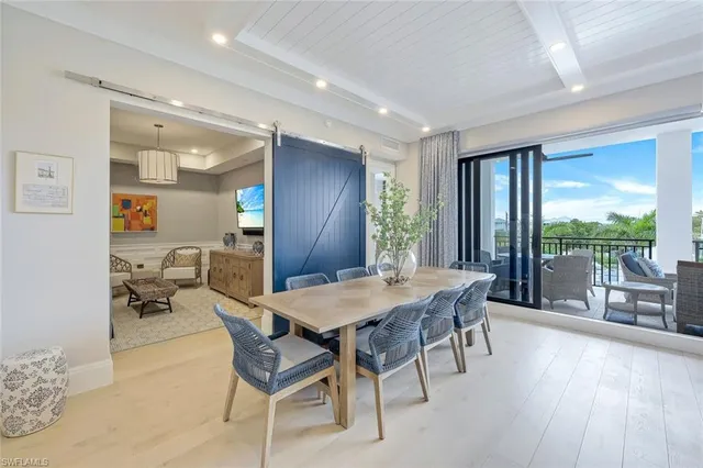 a view of a dining room with furniture large windows and wooden floor