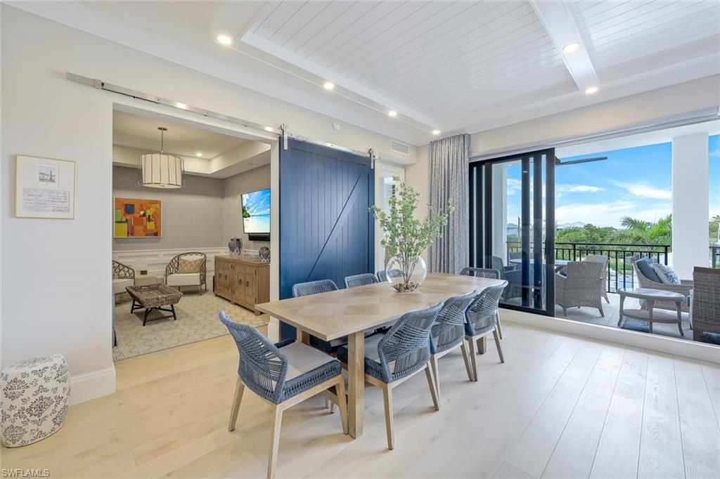 1135 3rd Avenue South, Unit 319 Naples, FL 34102 - Photo 7 of 19 a view of a dining room with furniture large windows and wooden floor