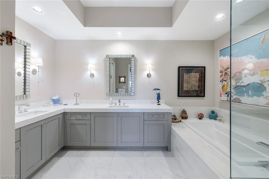 1135 3rd Avenue South, Unit 319 Naples, FL 34102 - Photo 9 of 19 a large bathroom with a double vanity sink mirror and bathtub